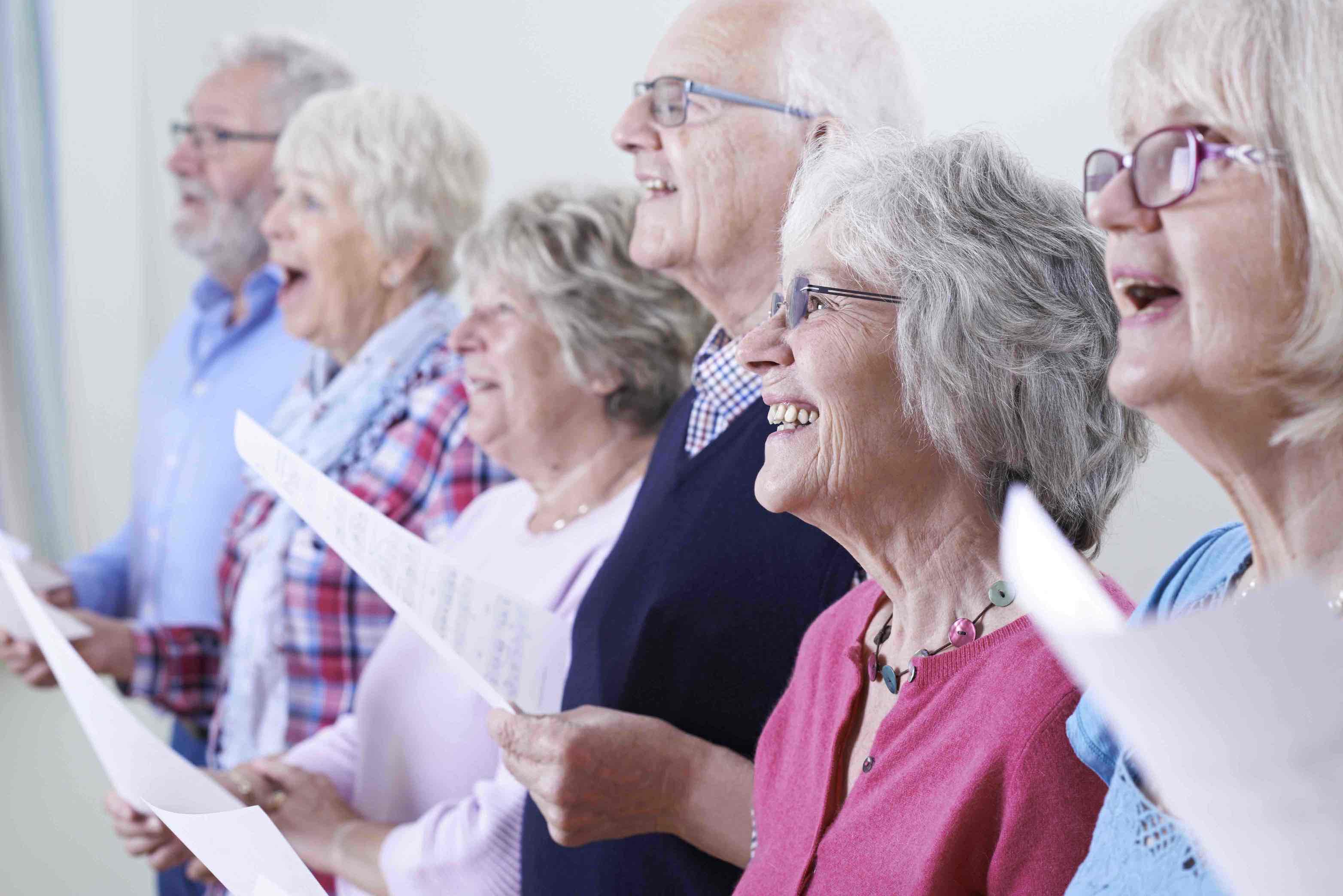 Много пожилых людей. Пенсионеры поют. Хор пенсионеров. Пожилые люди поют. Люди третьего возраста.