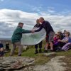 Devon Ramblers chairman Andrew Chadwick presents £500 cheque to Dartmoor Way project manager Michael Owen at the 50th anniversary celebration picnic on Hookney Tor (photo credit: Peter Walker)