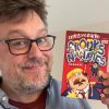 Chris McGuire holding his book