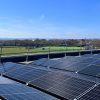 Roof mounted solar panels with football training in the background 