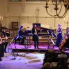 Orchestra playing separate instruments at concert