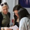 Queen Elizabeth's School GCSE Results Day Three people gather indoors, reviewing exam results; an older woman leans beside two young women.
