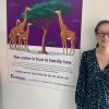 Two women next to poster