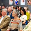 People sitting in rows looking at a series of portraits