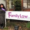 Woman standing by sign