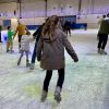 A teenage girl ice skating on ice rink