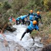 People in Hospiscare t-shirts scramble through a gorge
