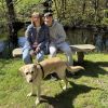 Fosterer Liese and trainee guide dog Agatha. Fosterer Liese and her son sit on a bench with trainee guide dog Agatha in front of them.