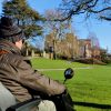 User of mobility scooter with Powderham Castle in the background