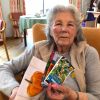 Resident Mary Skipworth, age 96, holds samples of the seed packets that were sent to the nursery children