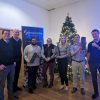 staff who raised money for charity standing in front of a christmas tree