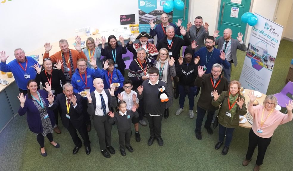 Supporters, students and staff from the Deaf Academy are pictured using the BSL sign for applause