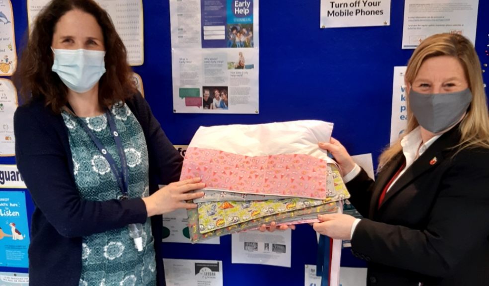 Caz Denning (right) handing her hand-sewn syringe rolls to Lucy Leymen, a nurse at Vranch House School.