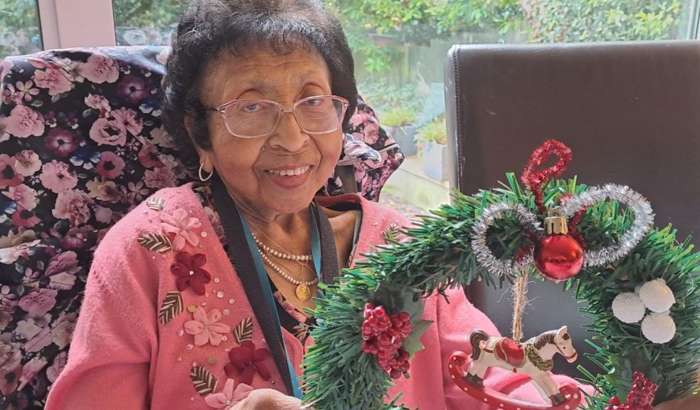 A lady making a Christmas wreath in a cosy home environment