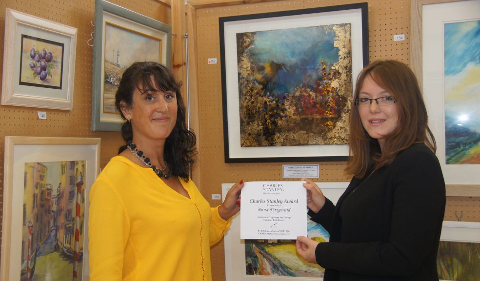 Anna Fitzgerald, seen here receiving her award from Emma Matthews of Exeter based wealth managers Charles Stanley & Co