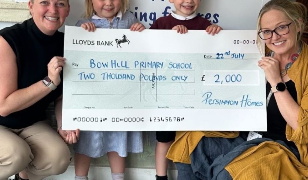 Local developer helps out Exeter school Teachers and children holding a cheque for £2000