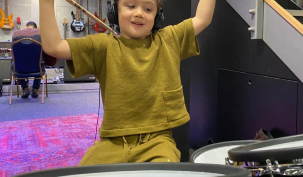 Little boy playing the drums in music studio