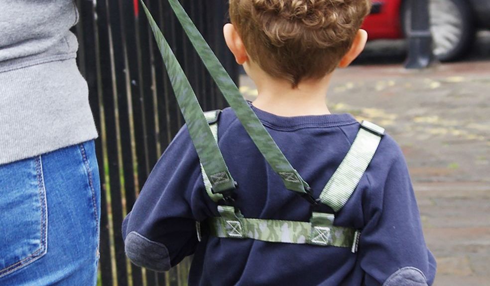 Toddler wears ONK baby reins in camouflage. Toddler walking on pavement in camouflage baby reins