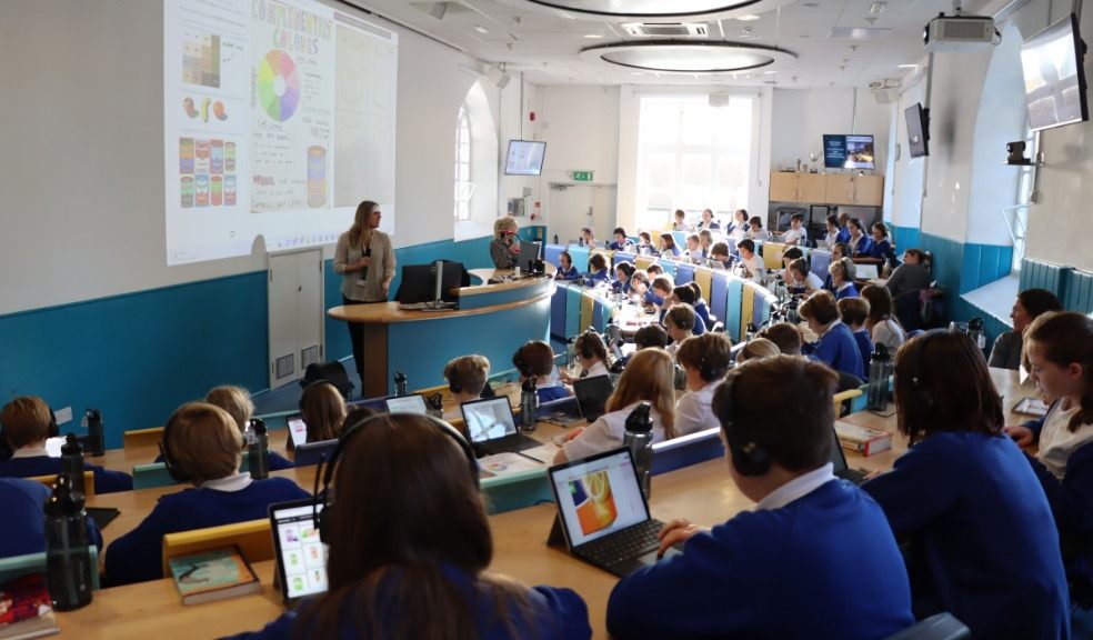 Children in uniform working with digital devices in the Year 6 lecture theatre