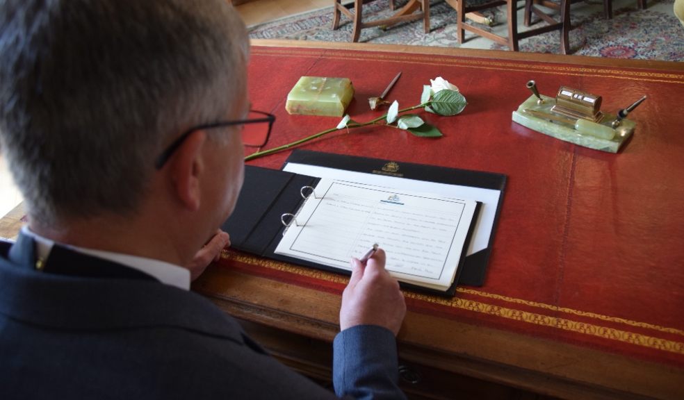 Chairman of Devon County Council Ian Hall signing the Book of Condolence