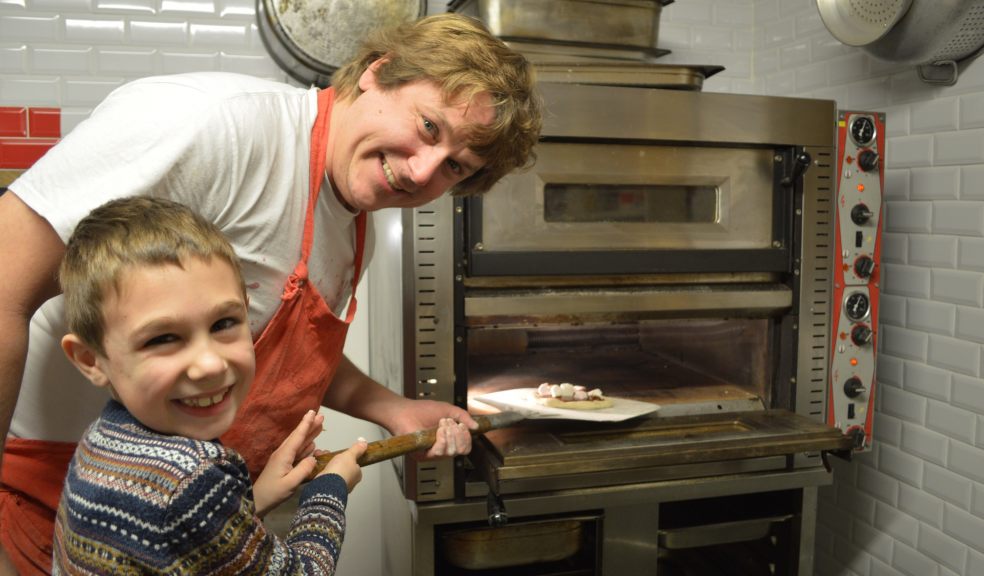Robin tests the pizza oven with a helper from Ottery St Mary Primary School