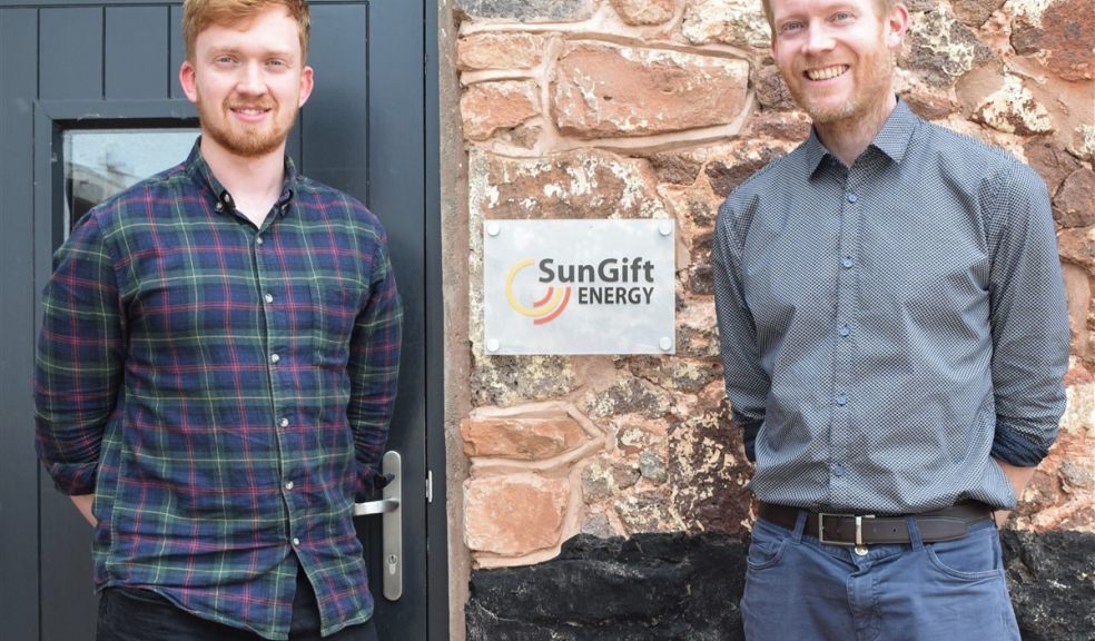 Two men in front of sign