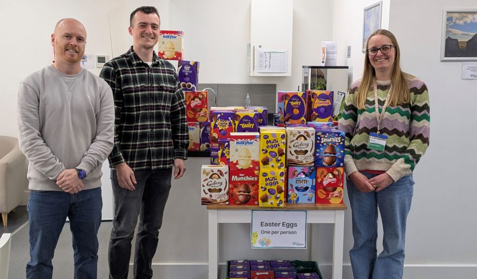 Three people at Exeter Foodbank with a large collection of Easter eggs