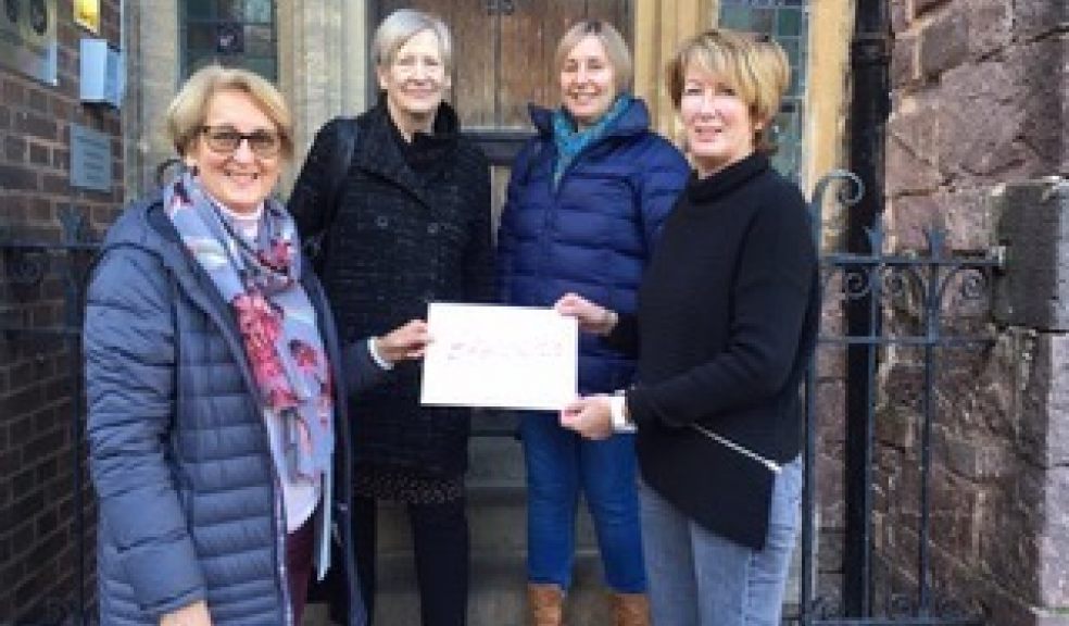 Choir members hand over the money to St. Petrock's