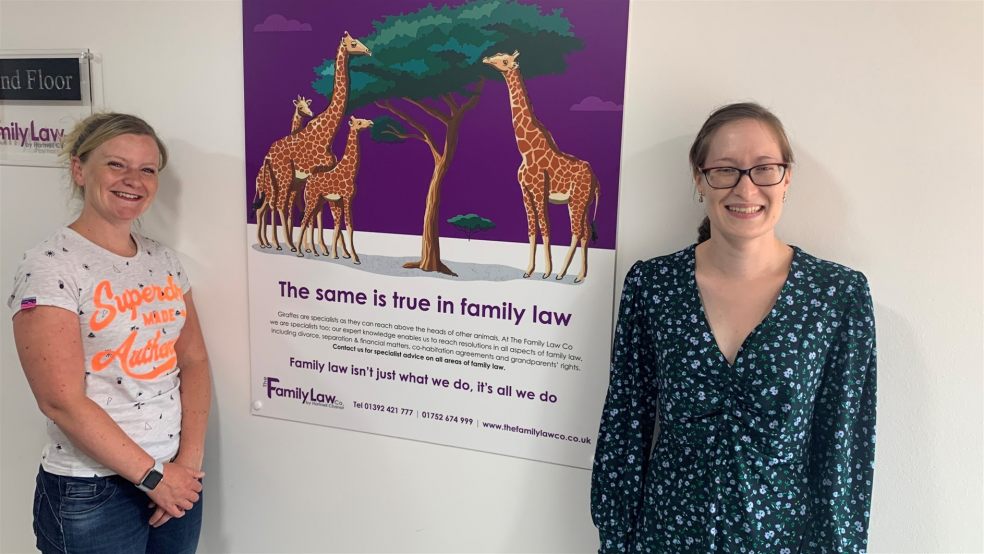 Two women next to poster