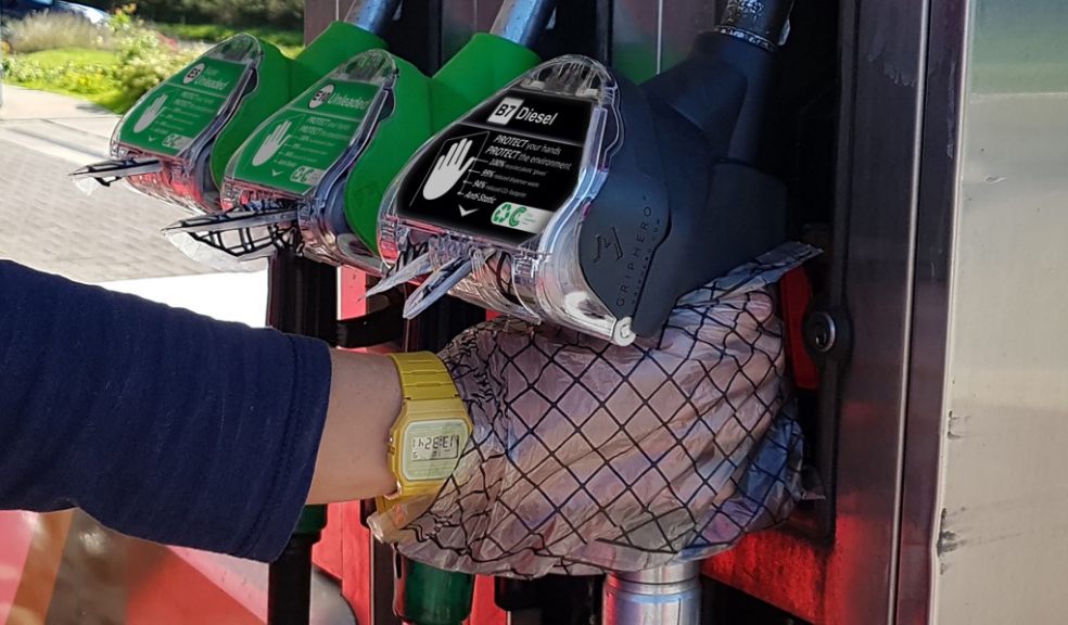 hand wearing GripHero glove gripping a grey fuel pump