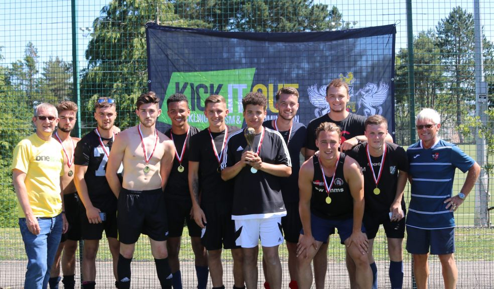 Marcel's Allstars, men's winners of the Exeter City Supporters Trust’s One Game One Community Group community diversity football tournament, with Alan Quick from ECFC OGOC group, left and Kevin Hack, right, from ECFC.