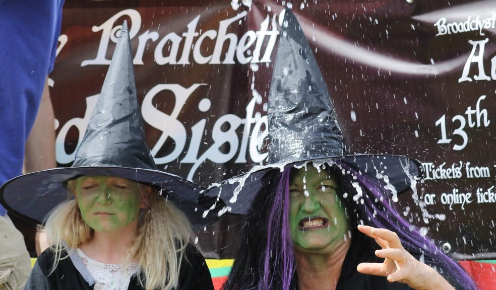 Terry Pratchett's Wyrd Sisters witches sat in the stocks to raise funds and promotesBroadclyst Theatre Group's next productionhe stocks
