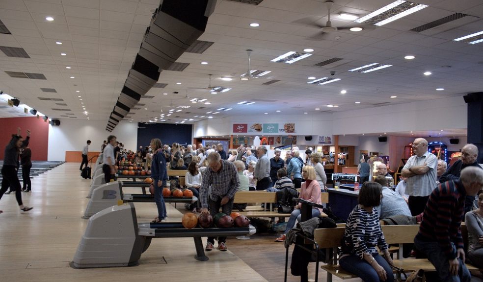 Lots of people bowling in a bowling alley