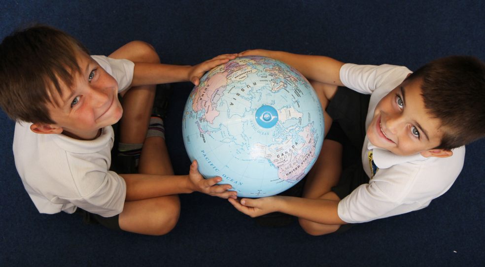 Children pose with a globe
