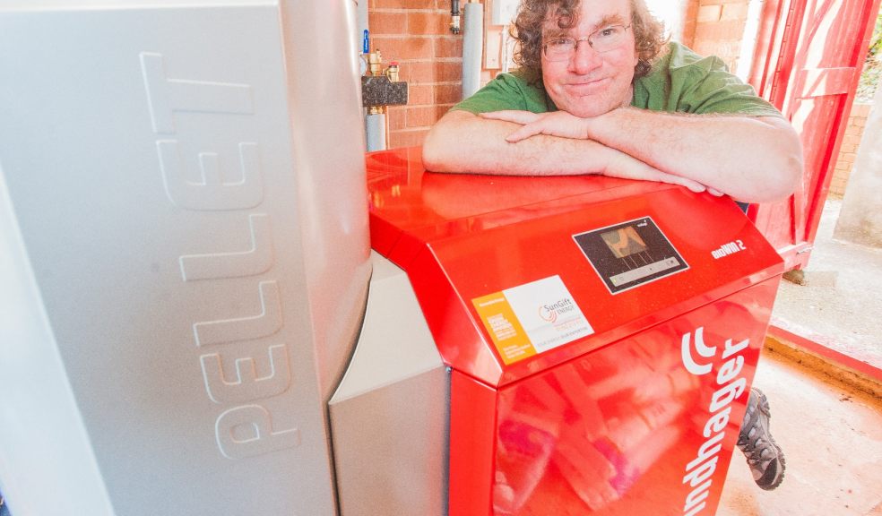 Climate Scientist Jeff Ridley shows off his biomass boiler, which - along with his solar PV and solar thermal panels – has hugely reduced his home's carbon emissions.