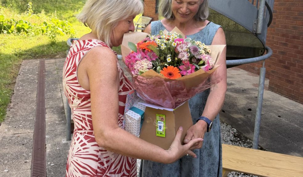 Kay receiving flowers from Mary Jane Campbell