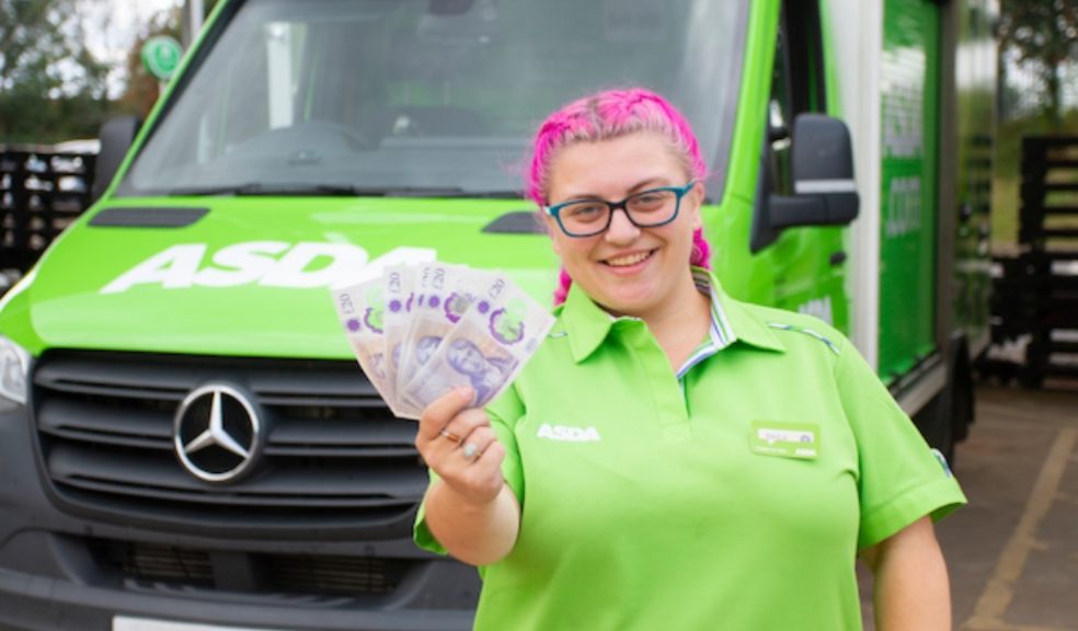 Woman with pink hair holding money in front of an Asda supermarket van