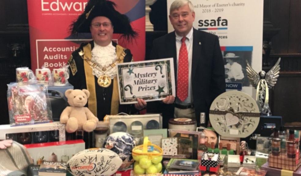Lord Mayor of Exeter, Councillor Rob Hannaford, and John Coombs, partner at Simpkins Edwards, with auction and raffle items for The Really Big Quiz.