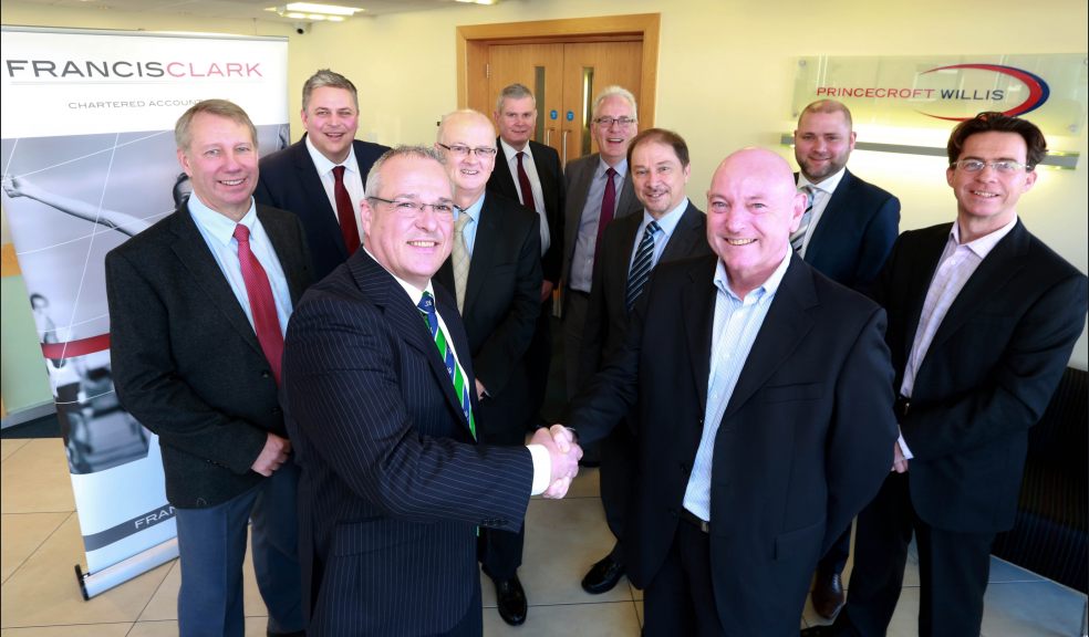Sealing the deal: Andrew Richards, Francis Clark's Managing Partner Elect (front left) and Mark Johns, Managing Director, Princecroft Willis (front right) shake hands on the merger watched by directors and partners from both firms.