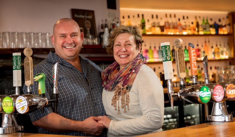 Two people behind a bar