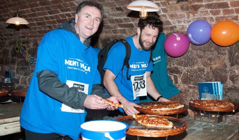 Men's Walk participants in Hospiscare t-shirts enjoy a pizza en route