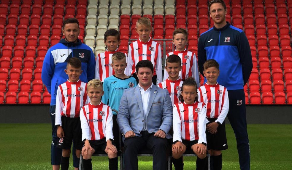 Brad Lee-Miller, top left, and Arran Pugh, top right, of Exeter City Academy, are pictured with Craig Collett of IP Office, centre front, and players from the academy’s Under 9 team.