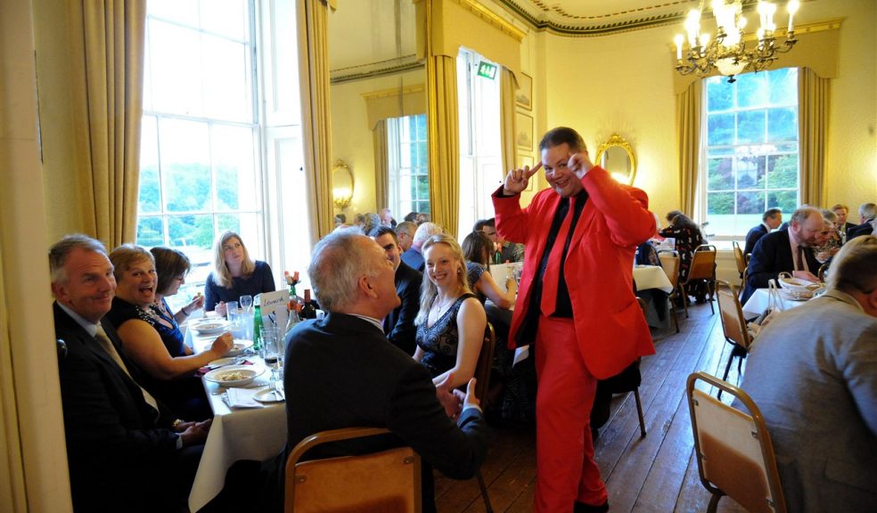 Red Suit Magician entertains diners at Red Squirrel fundraiser 2017 Dinner at Escot House