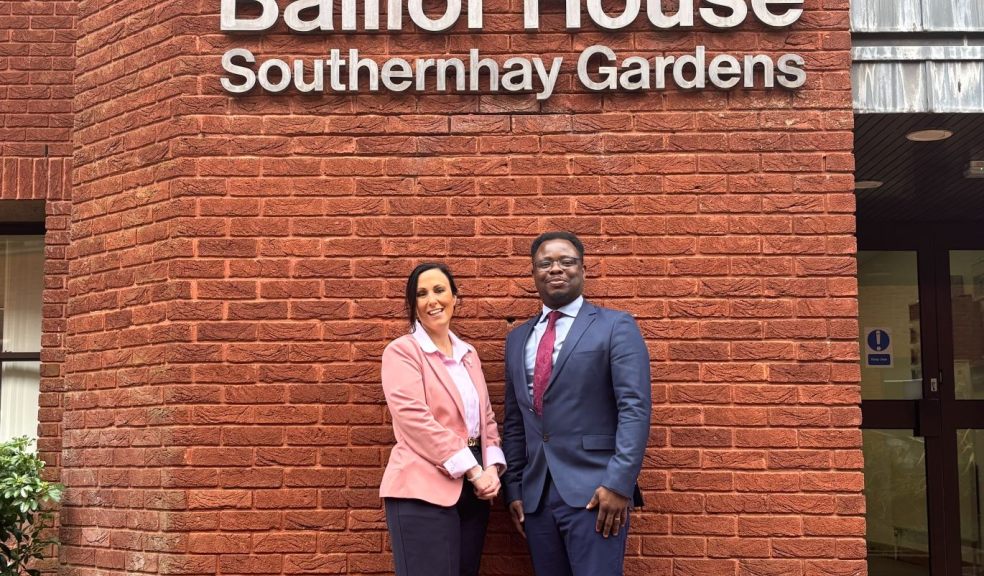 Two solicitors standing outside a sign for Balliol House in Exeter