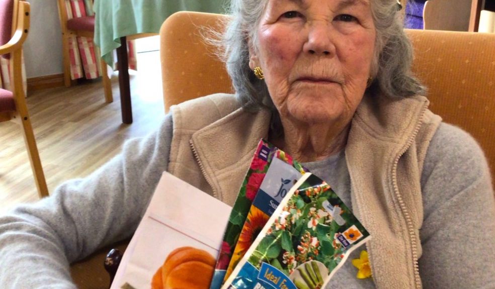 Resident Mary Skipworth, age 96, holds samples of the seed packets that were sent to the nursery children