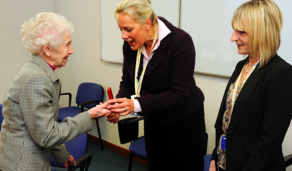 Doris Sumption receives her replica medal from RD&E Deputy Chief Executive/Chief Nurse Em Wilkinson-Brice, with Support Secretary Stephanie Collins.