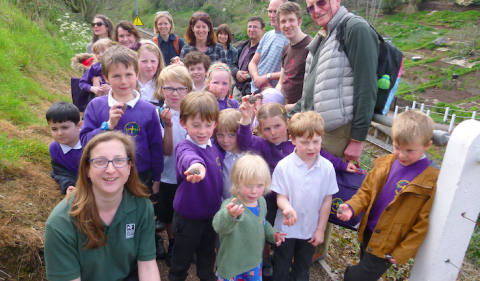 Children from St Sidwell’s CE Primary School with their parents and Devon Wildlife Trust’s Emily Stallworthy arrive at St James’ Park station to plant wildflower seeds.