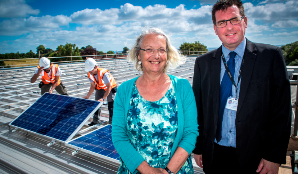 Gill Wyatt, Exec Chair of Exeter Community Energy, and (right) Steve Strang, Head of Estates at Exeter College, with in the background Nuku Wondrausch (left) and Ashley Commins (right) from SunGIft Solar.