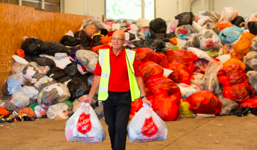 A Salvation Army worker collecting bags of donated textiles.