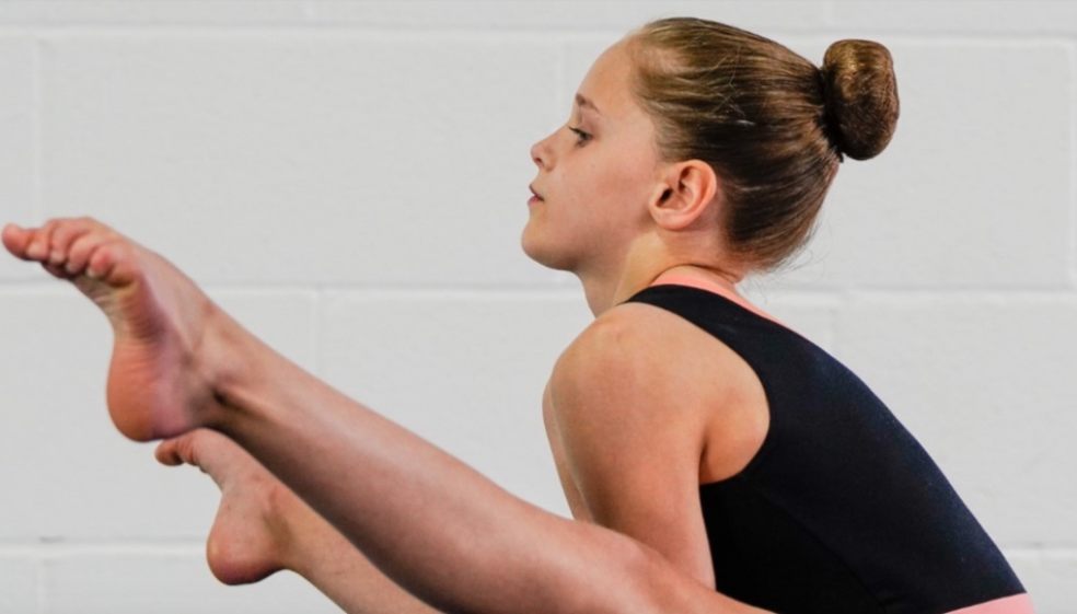 Hallie Bennett does a straddle lever on blocks